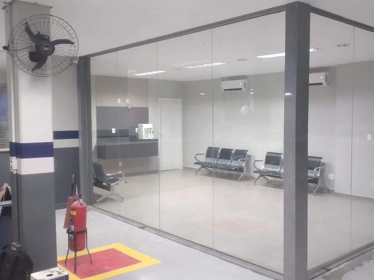 Edificação com andaime, proteção de calçada e equipe em intervenção na fachada.