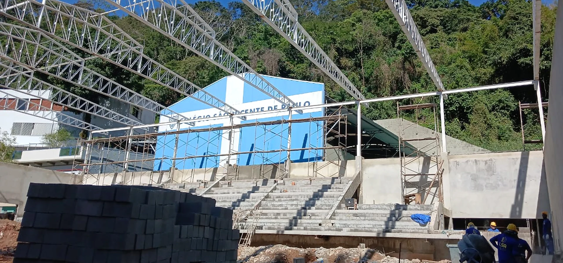 Edificação em intervenção, com plataforma de trabalho e proteção da área no nível da rua.